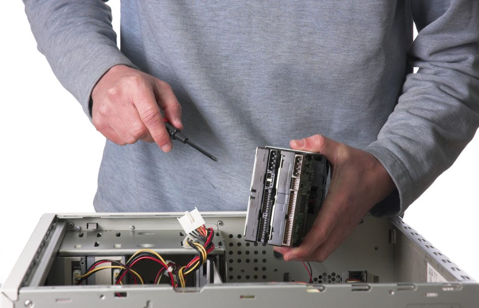 Personne qui répare un disque dur interne en panne pendant la formation d'installateur dépanneur informatique, titre professionnel à Formasoft